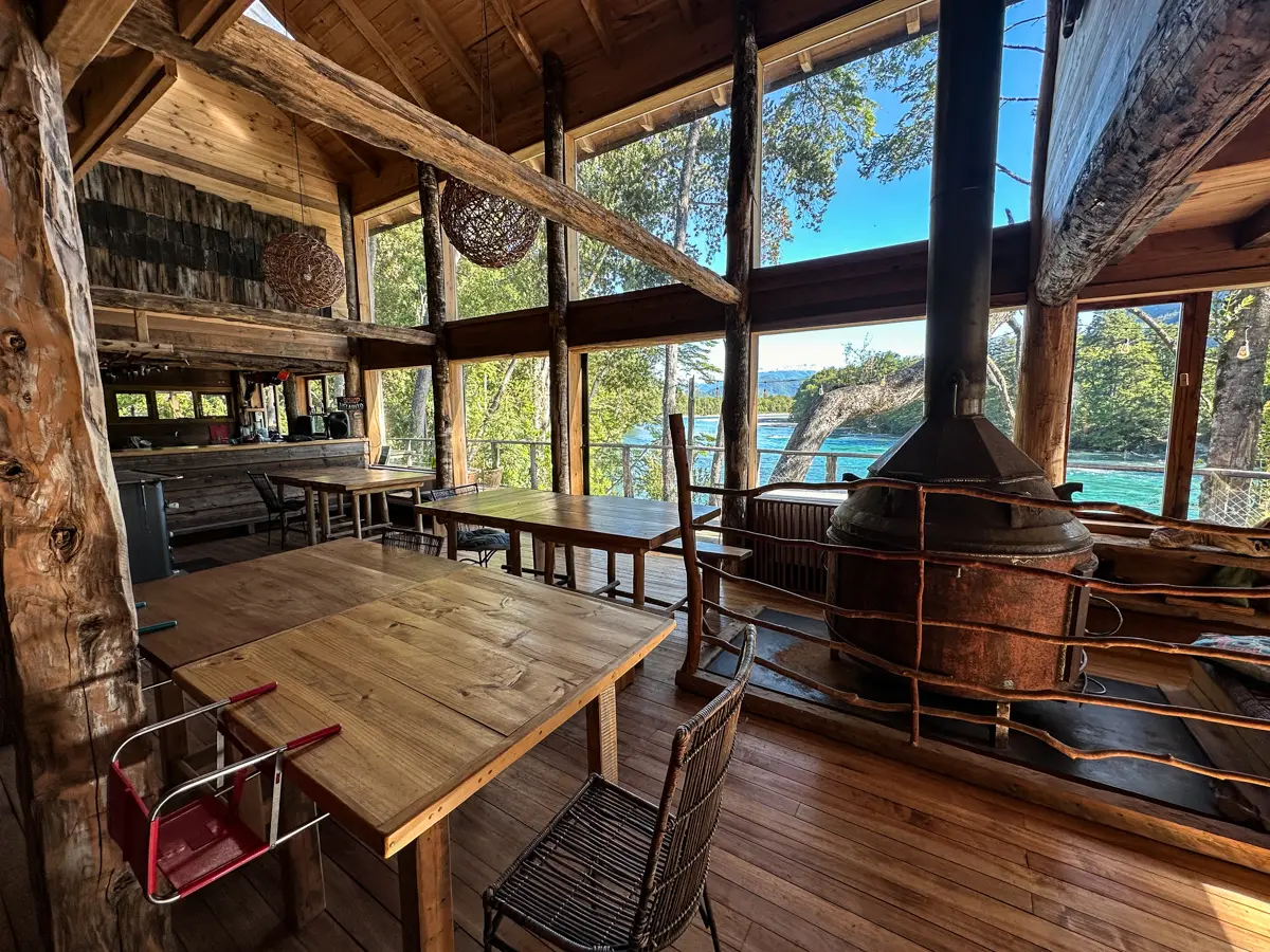 The hostel dining room, wood stove and windows over the river